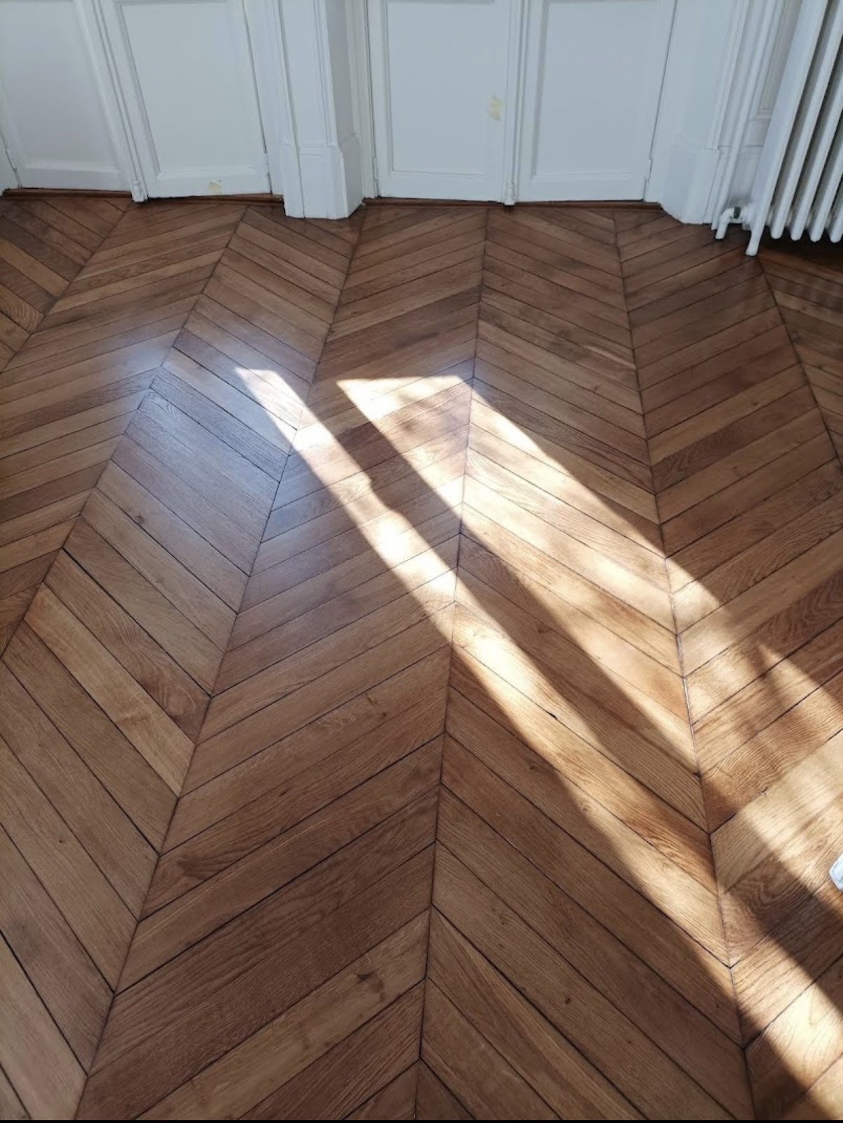 Parquet ancien vitrifié dans une pièce lumineuse