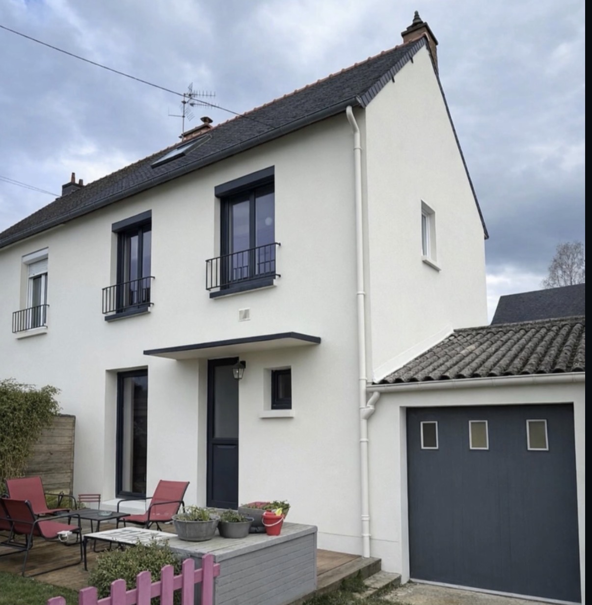 Maison rénovée avec façade blanche et menuiseries anthracite